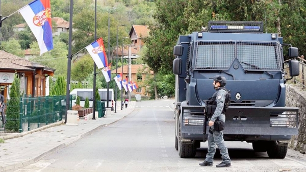 A Kosovo police officer stands guard in front of a vehicle with a cracked window in Banjska. — courtesy Reuters