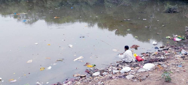 A man fishes on the banks of the Mithi River in western India that has become an open dump for sludge oil and hazardous chemicals. — courtesy UNICEF/Magray