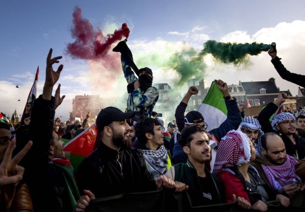 Protesters wave Palestinian flags during a rally in support of Palestinians in Amsterdam on October 15, 2023. Gunmen from the Islamist Hamas burst across the Gaza border with Israel on October 7 and shot dead more than 1,300 people, including civilians. In response, Israel has mounted a withering campaign of air and artillery strikes on Gaza that has killed 2,450 people. (Photo by Robin van Lonkhuijsen / ANP / AFP) / Netherlands OUT (Photo by ROBIN VAN LONKHUIJSEN/ANP/AFP via Getty Images)