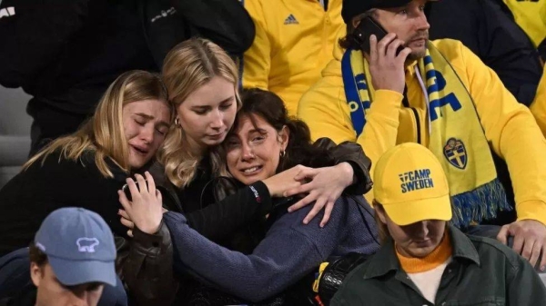 Swedish supporters react at the King Baudouin Stadium after two people were killed in a shooting in Brussels.