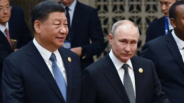 Chinese leader Xi Jinping and Russia's President Vladimir Putin head to a group photo session during the third Belt and Road Forum at the Great Hall of the People in Beijing on October 18