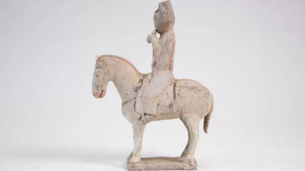 A Tang Dynasty-era figurine of a rider on horseback blowing a wind instrument