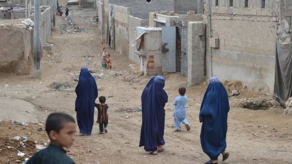 Afghan women walk through a refugee camp in Karachi.