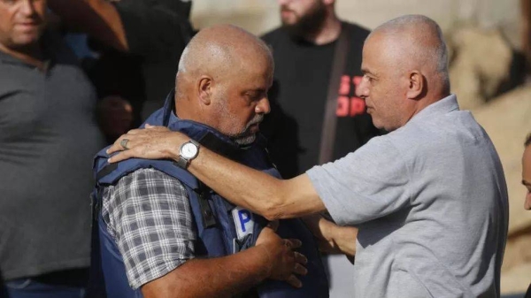 Wael Al-Dahdouh (left) at the funeral for his family members.