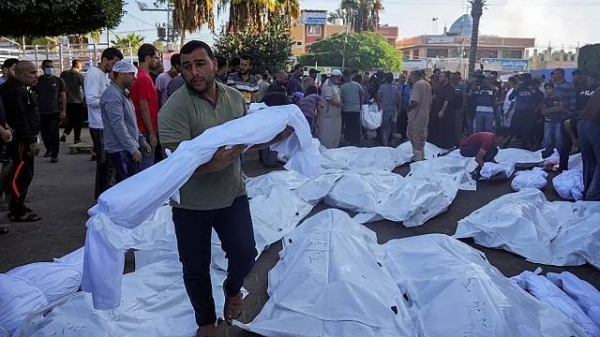 Palestinians mourn relatives killed in the Israeli bombardment of the Gaza Strip in front of the morgue in Deir al Balah, Monday, Nov. 6, 2023