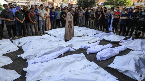 Palestinians mourn relatives killed in the Israeli bombardment of the Gaza Strip in front of the morgue in Deir al Balah, Monday, Nov. 6, 2023.