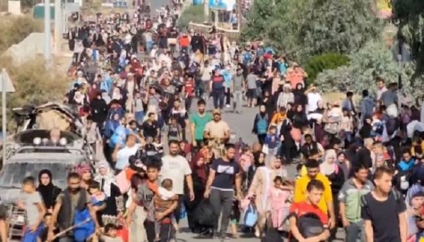 Groups of people walk along Salah a-Din road as they evacuate south from Gaza City.