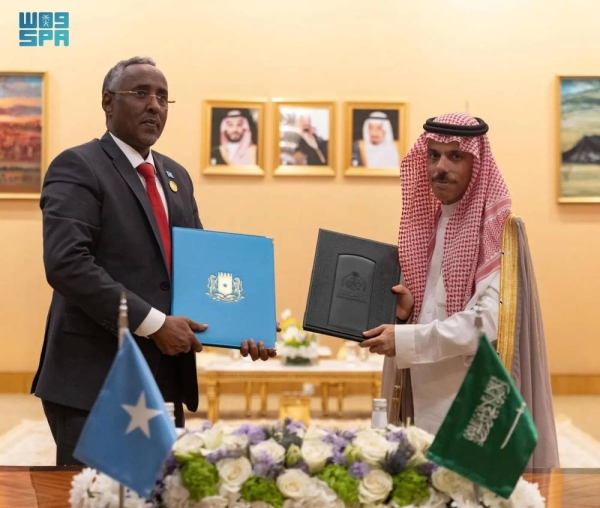 Prince Faisal bin Farhan and Somalia's Faisal bin Farhan exchange documents after signing the agreement.