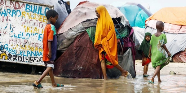 Residents wade through flood waters following heavy rains, on the outskirts of Mogadishu in Somalia, on Nov. 19, 2023. — courtesy Reuters