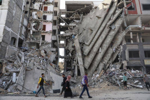 Palestinians walk through destruction in Gaza City on November 24, as the temporary truce between Israel and Hamas took effect.