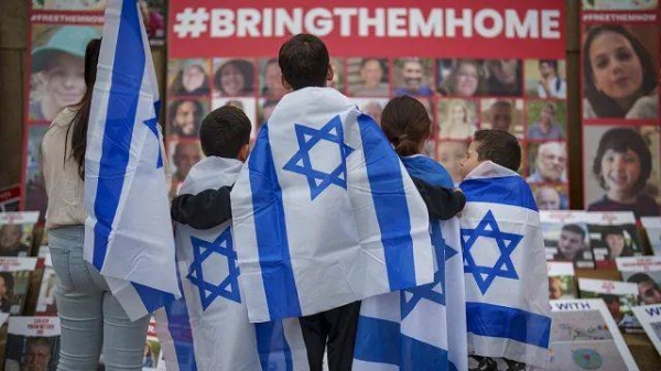 Children look at photographs of kidnapped Israelis during a rally joined by hundreds in solidarity with Israel and those held hostage in Gaza, in Romania