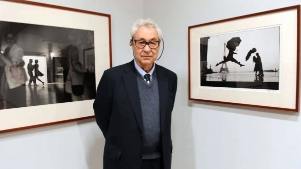 An 82-year-old Erwitt poses in front of some of his work at an exhibition in Paris, where he was born in 1928