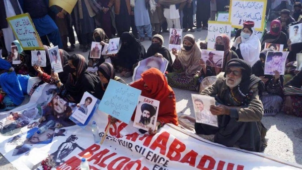 Protesters hold photos of their missing relatives, during a protest against forced disappearances in Dera Ismail Khan