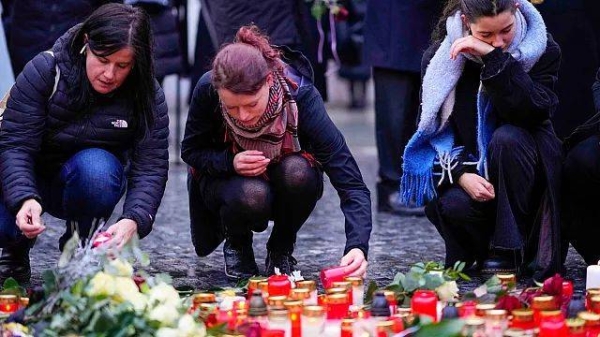 Mourners lay candle lights outside the headquarters of Charles University for victims of mass shooting in Prague, Czech Republic, Friday, Dec. 22, 2023