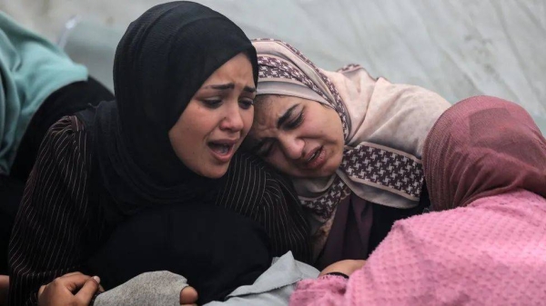 Women at Al-Aqsa hospital in central Gaza mourn their loved ones killed in what Hamas says was an Israeli strike on the Al-Maghazi refugee camp on Sunday