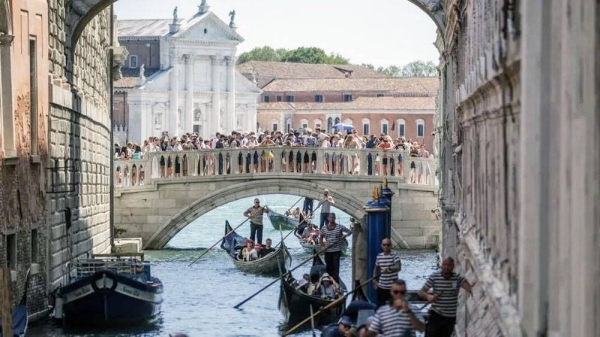 Gondolas slowly pass under the Bridge of Sighs near St. Mark’s Square due to too much traffic in Venice, August 2023. — courtesy Getty Images