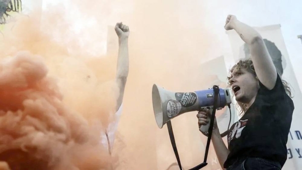 A protester with a megaphone stands in front of a cloud of smoke outside the Supreme Court in September last year. — courtesy Getty Images