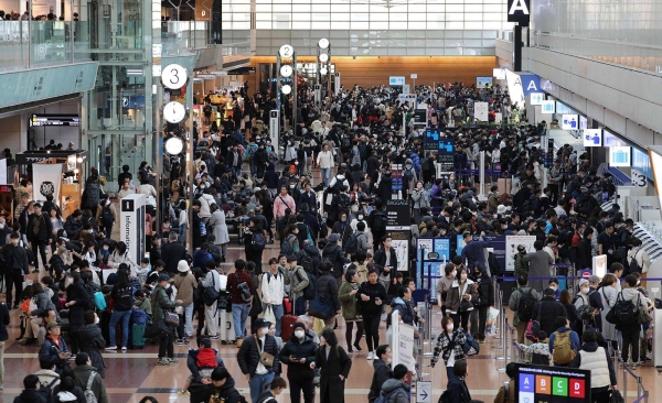 Travelers crowd the check-in area at terminal 2 at Tokyo's Haneda Airport on January 3, 2024.