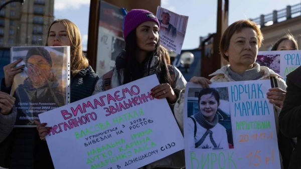 People hold the posters 'Freedom to civilian prisoners' while attending a meeting in support of civilian women imprisoned by Russia, on Independence square in Kyiv, Ukraine