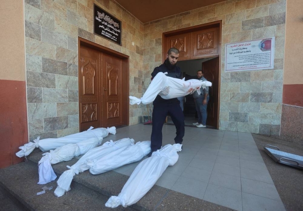 A man carries a body of a Palestinian killed in Israeli strikes on Al-Mawasi, according to a health ministry official, at a hospital in Khan Younis in the southern Gaza Strip January 4, 2024. REUTERS/Ahmed Zakot