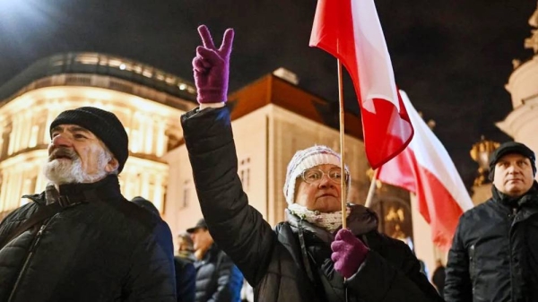 People hold banners and shout slogans as they take part in a protest against a warrant for the former Minister of the Interior of Poland in front of the Presidential Palace in Warsaw, Poland. — courtesy Getty Images