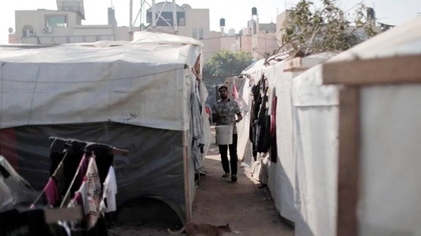 Man stands near tents at UNRWA training college in Khan Younis. — courtesy UNRWA