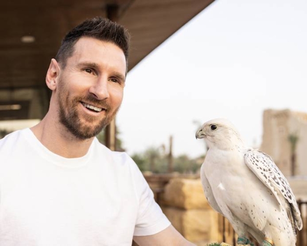 Messi holds a white falcon in Saudi Arabia.