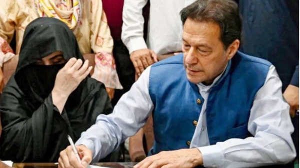 Imran Khan and his wife Bushra Bibi sign surety bonds for bail in July 2023, — courtesy Getty Images