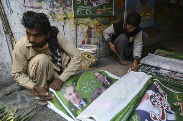 Workers prepare election campaign posters of the Pakistan Muslim League (N) party in Rawalpindi on January 10, 2024
