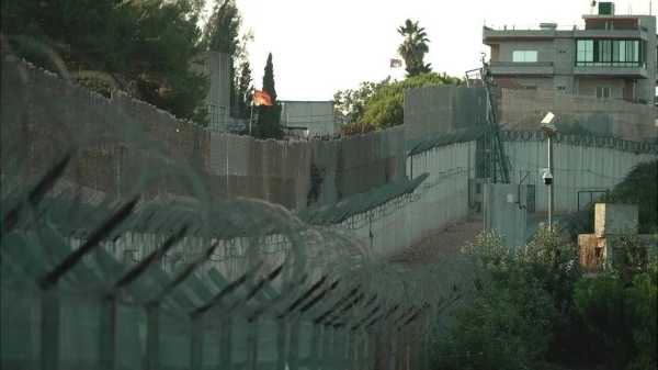 Barbed wire fencing and cameras run along the border at the Israeli town of Metula