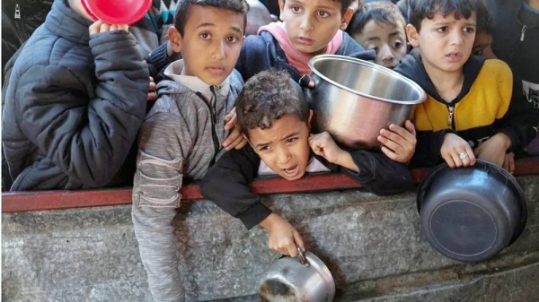 Palestinian children wait to receive food cooked by a charity kitchen in Rafah, southern Gaza. — courtesy Reuters