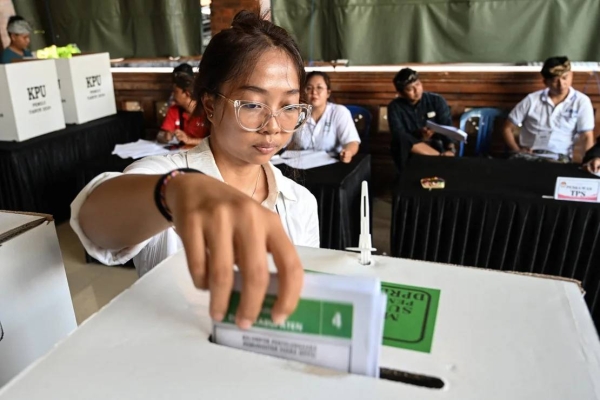 A woman casts her ballot in Banjar Teba, Jimbaran on the resort island of Bali on February 14, 2024