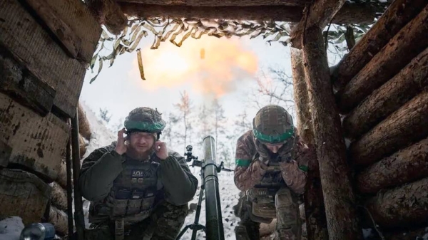 Two Ukrainian soldiers duck after firing a mortar. —courtesy Getty Images