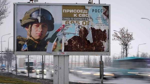 Cars drive past an advertising billboard in St. Petersburg promoting contract military service in the Russian army