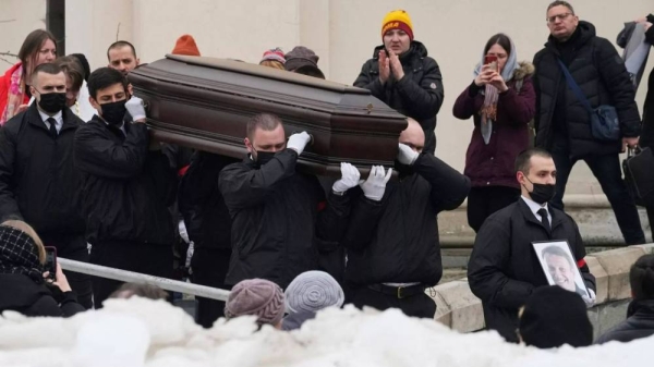 Workers carry the coffin and a portrait of Russian opposition leader Alexei Navalny out of the church