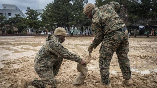 US Marine Corps Cpl. Jamyrion V. Stewart, left, and Sgt. Frederick B. Osei fill sandbags while building a combined command post in preparation for Freedom Shield 24 in Pohang, South Korea, Feb. 25, 2024