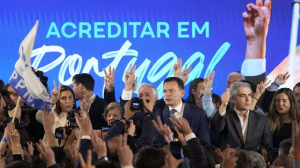 Luis Montenegro, leader of the center-right Democratic Alliance, center, and his wife Carla, at left, gesture to supporters after claiming victory in Portugal's election, in Lisbon