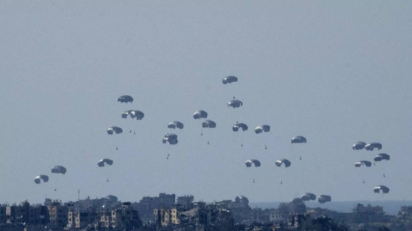 Parachutes drop humanitarian aid into the northern Gaza Strip, as seen from southern Israel, Monday