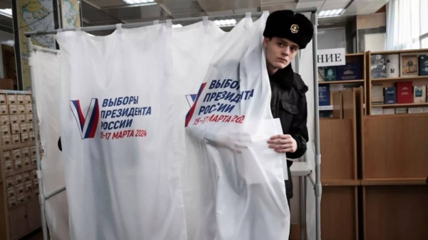 A student of the Maritime State University named after Admiral Gennady Nevelskoy leaves a voting booth at a polling station during a presidential election