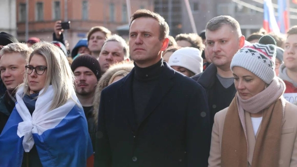 In this February 2020 photo, Alexey Navalny and his wife Yulia walk with demonstrators during a rally in Moscow, Russia