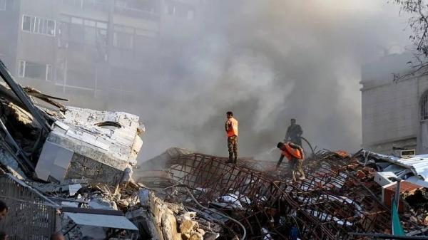 Emergency services work at a destroyed building hit by an air strike in Damascus, Syria, Monday, April 1, 2024