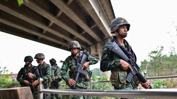 Thai military personnel stand guard overlooking the Moei river on the Thai side, near the Tak border checkpoint with Myanmar, in Thailand's Mae Sot district on April 10, 2024