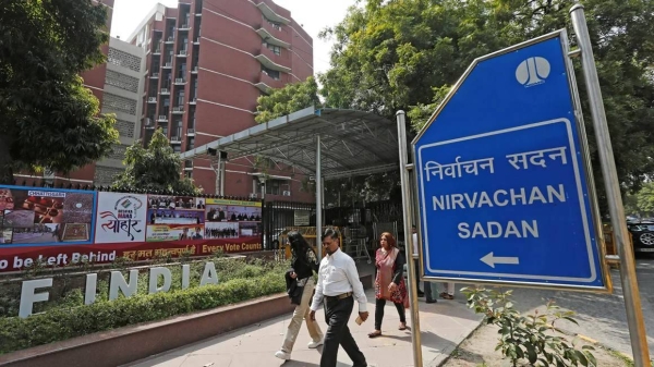 Pedestrians walk past the Election Commission of India offices in New Delhi