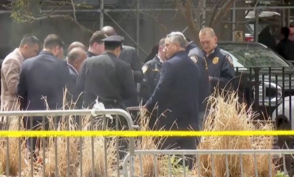 Police inspect the area where a man set himself on fire outside the Manhattan court.