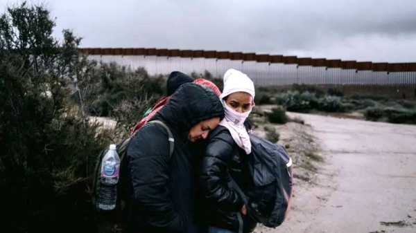 Migrants wait to be transported for asylum claim processing at the US-Mexico border in Campo, California, US. — courtesy Getty Images