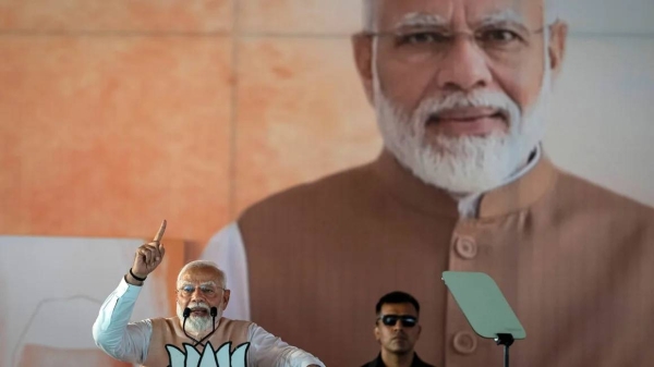 A large portrait of Indian Prime Minister Narendra Modi is displayed behind him as he speaks at an election campaign rally in Meerut, India, on March 31, 2024