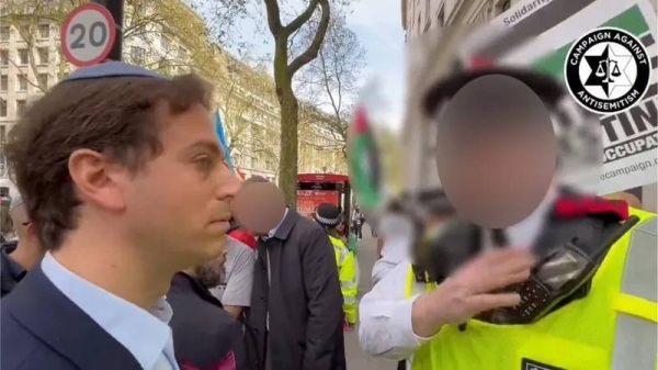 A police officer speaks to Gideon Falter. — courtesy Campaign Against Antisemitism/PA Wire