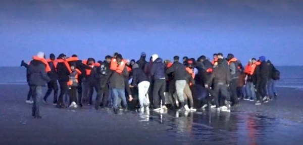 People clambering aboard a small boat bound for the UK.