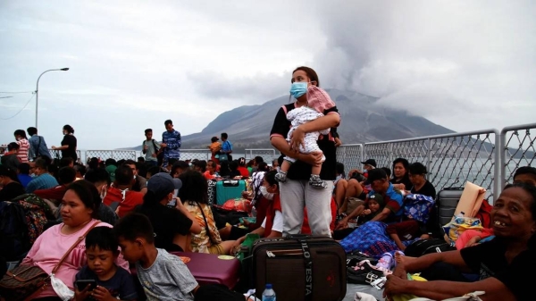 Families evacuate following eruptions of Mount Ruang volcano in North Sulawesi province, Indonesia, on May 1, 2024