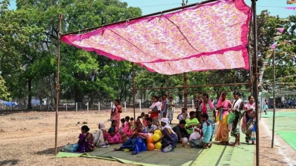 Voters take shelter from the sun outside a polling booth in Chhattisgarh state in April